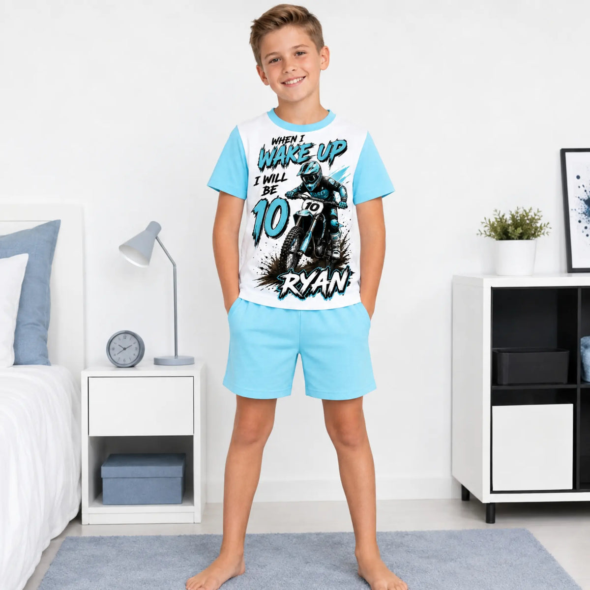 Boy wearing blue personalised motocross birthday pyjamas with shorts